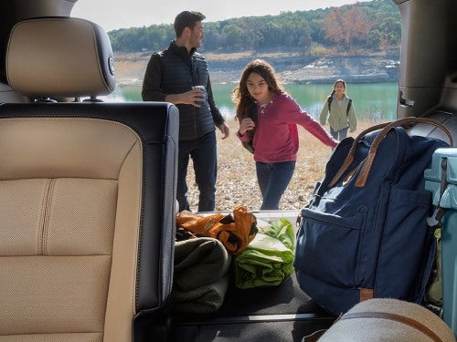 2024 Chevrolet Equinox interior view looking through the back with a family in the background with cargo area full of supplies