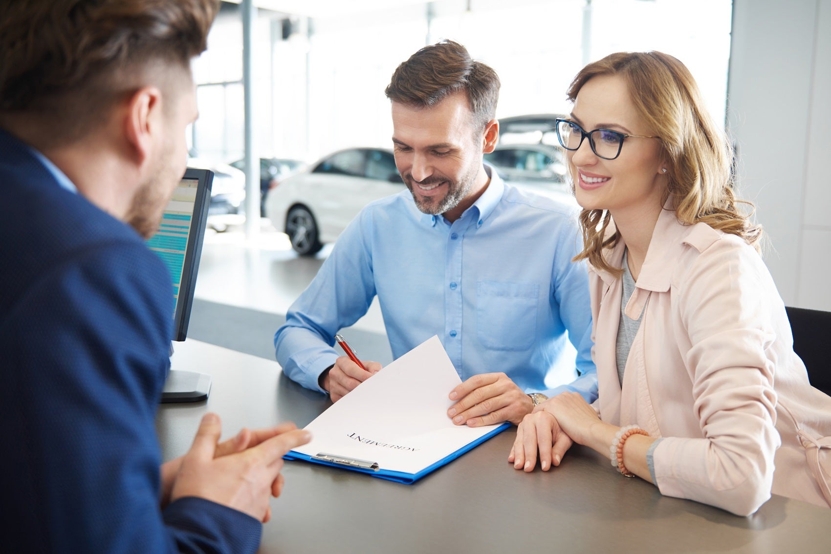 Couple signing paperwork for new Chevy vechicle with Chevrolet Financing team member