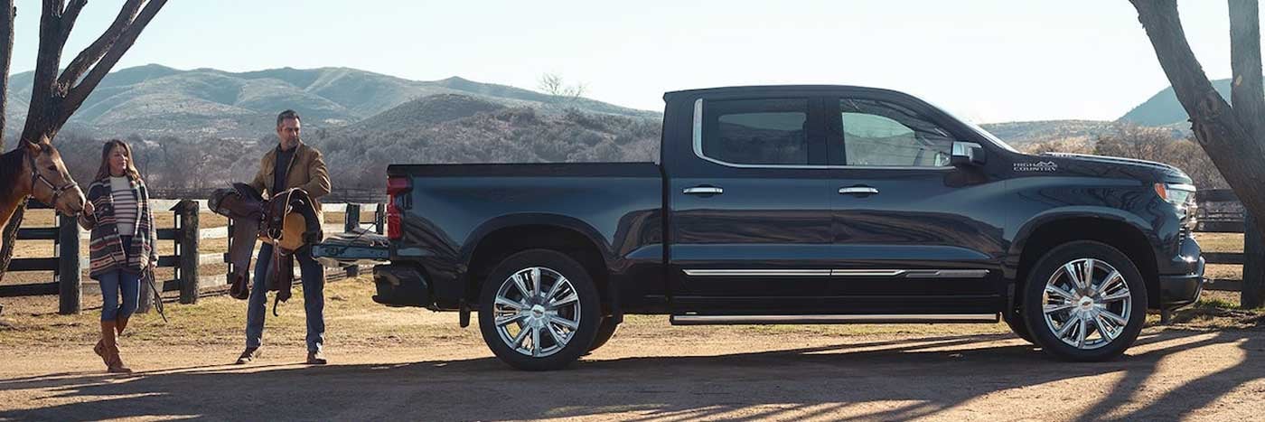 Couple loading bed of Chevrolet Silverado 1500 outdoors