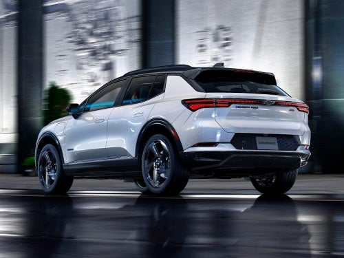 2024 Chevrolet Equinox EV driving on a city street at night