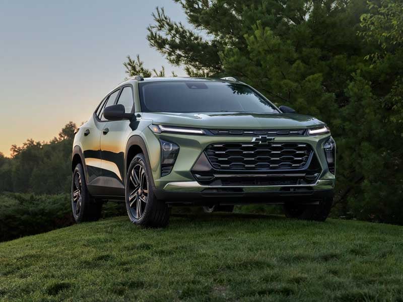 Chevrolet Trax parked on a grassy hill during sunset with trees in the background from Used Car dealer near Minneapolis, MN